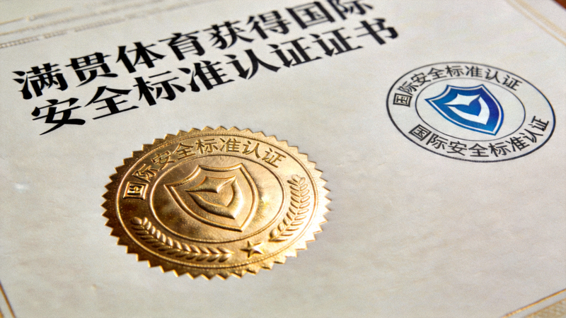 满贯体育获得国际安全标准认证证书特写，带有金色印章与认证标志